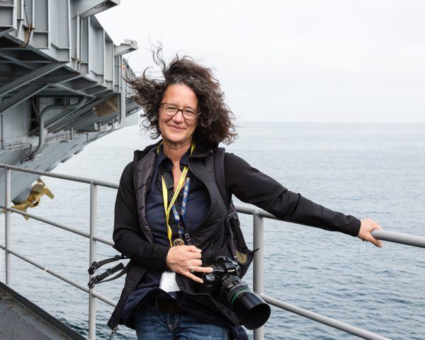 Elise Prudhomme, photographer, on the windy catwalk of the Nimitz-class aircraft carrier USS Theodore Roosevelt (CVN 71) cruising in the Pacific Ocean off of San Diego, California.