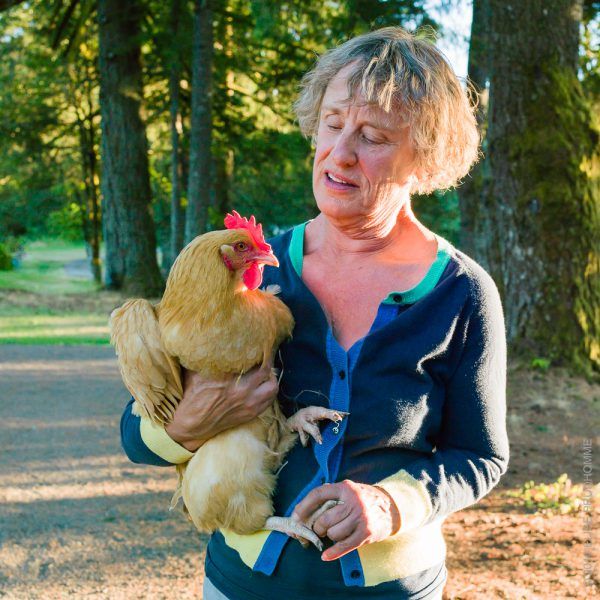 Christine Roosevelt Stimac holding an Araucana chicken on her fa