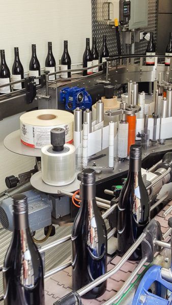 Three Feather bottles leave the StelvinLux screwcapping machine on the assembly line-up by Signature Bottlers.