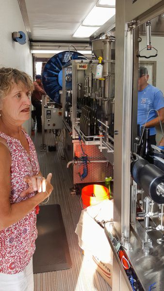 Three Feathers owner Christine Stimac surveys the bottling process at Lady Hill Winery.